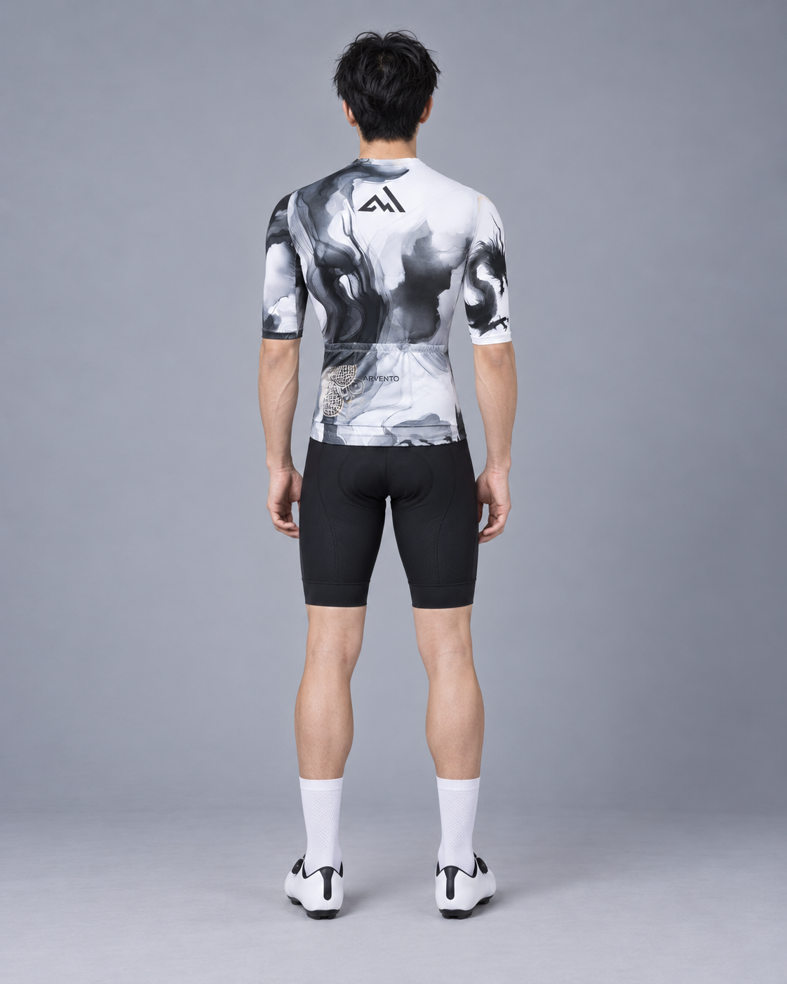 Full-body back view of a Taiwanese male cyclist wearing the ARVENTO ink-wash cycling jersey with three rear pockets.