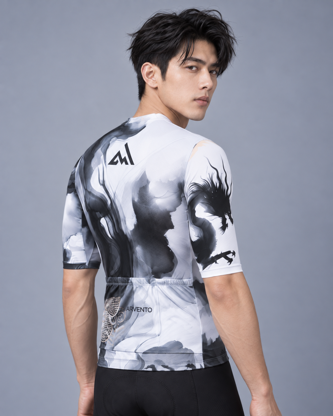 Three-quarter back view of a Taiwanese male cyclist wearing the ARVENTO ink-wash cycling jersey with rear pockets and dragon sleeve detail.